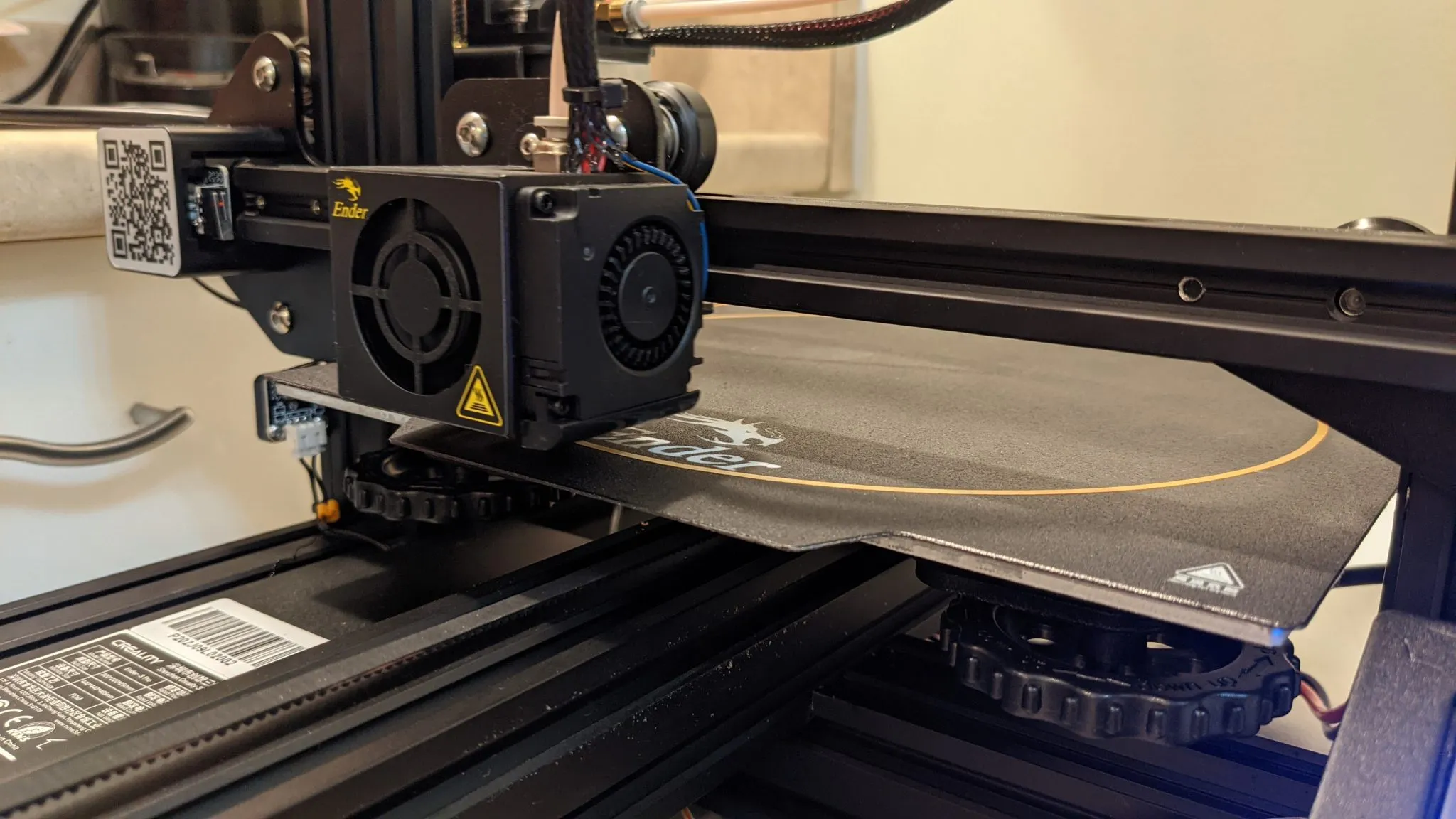 Primeira camada de uma peça sendo impressa na mesa de uma impressora 3D